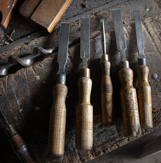 A set of carpentry tools lie on a workbench.