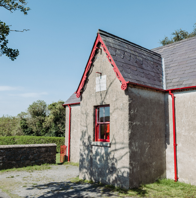 A hall with slate roofing and red trim around the features