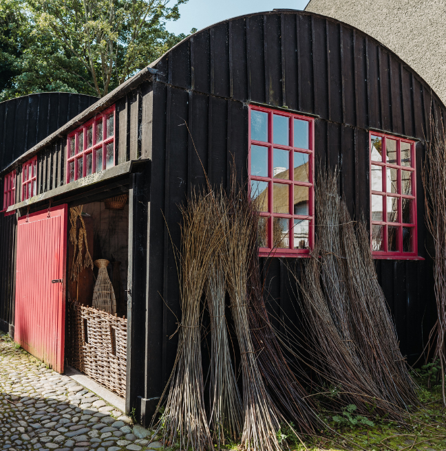 A black and red building with sheaths bundled outside.