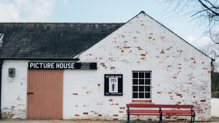 An old picture house, with a Charlie Chaplin poster on a board.