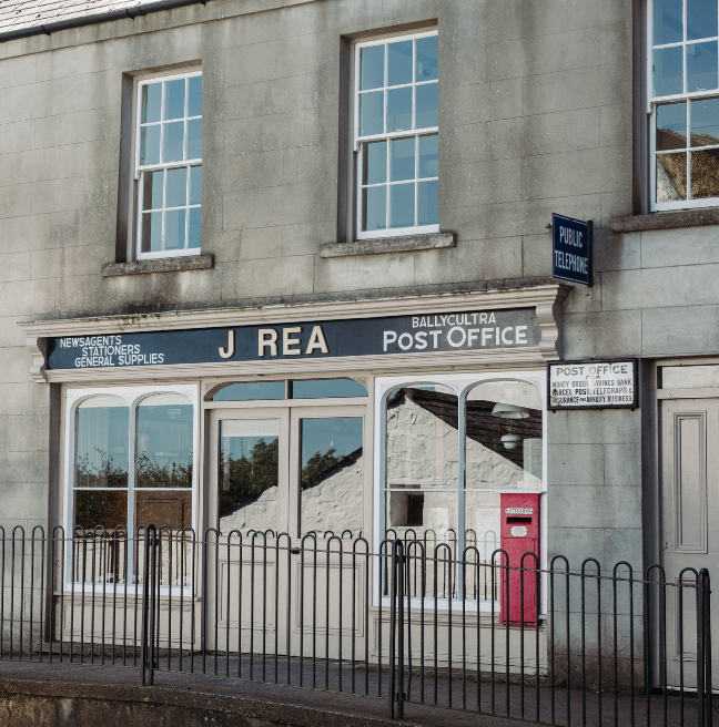 A post office's store front. The sign reads, 'J. Rea'.