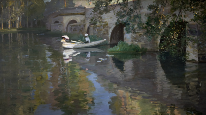 The Bridge at Grès (1901) by Sir John Lavery.  A view of the bridge at Grès with reflections of the brige and trees on the water. Two figures sit on a row boat on the river. The woman at the rear reclines with a pink parasol overhead.