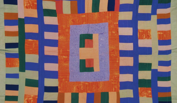 Close up of patchwork quilt made of blue orange pink green rectangles