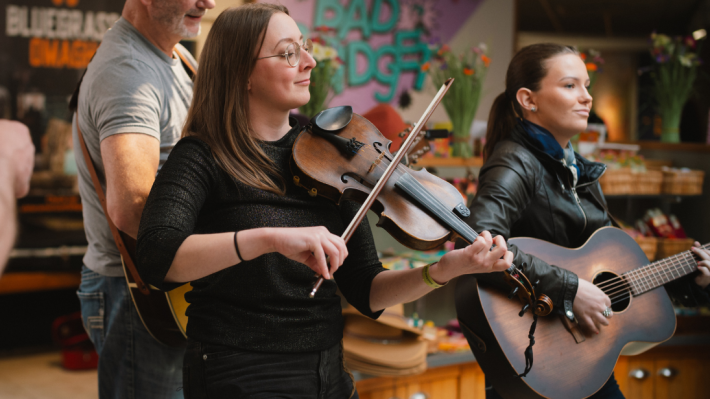 Two women playing fiddle and guitar