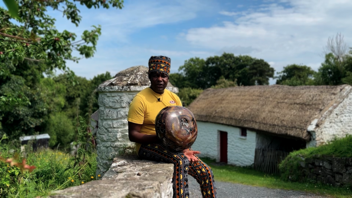 Agrippa sitting on a wall at the Ulster Folk Museum with the Mbira