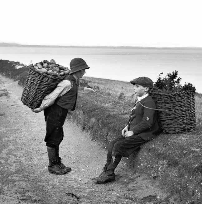 Two boys carrying potatoes