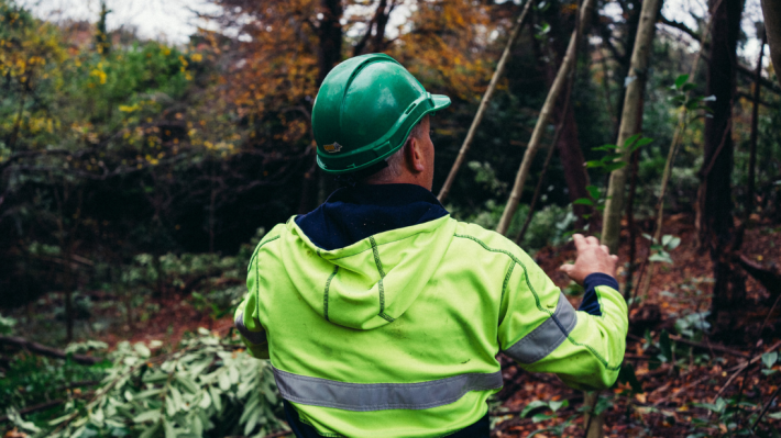 A man in a green hard hat and green jacket doing conservation work at the ulster folk museum