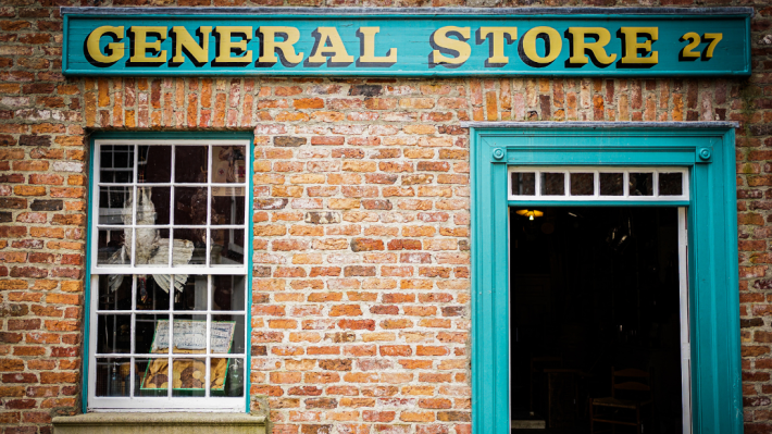 The exterior of a red brick general store.