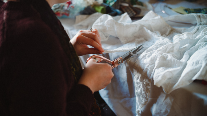  A lady cutting into material using scissors