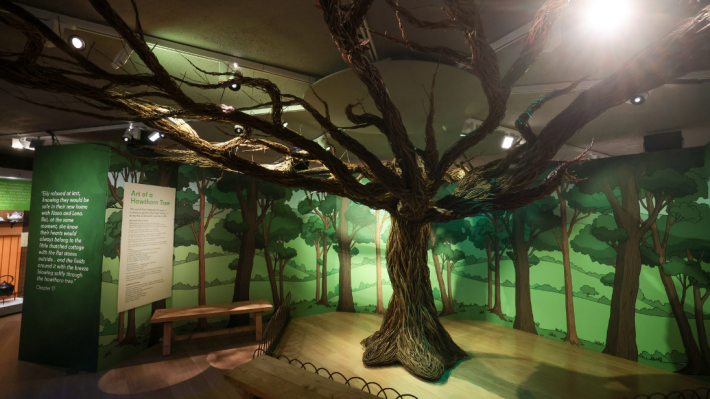 A hawthorn tree made by willow, situated in an exhibition display at ulster american folk park, with green backdrops