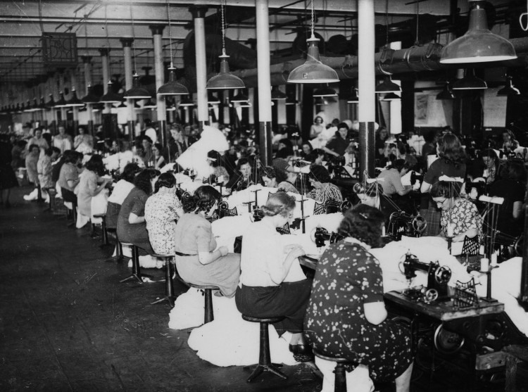 Female workers at sewing machines making parachutes