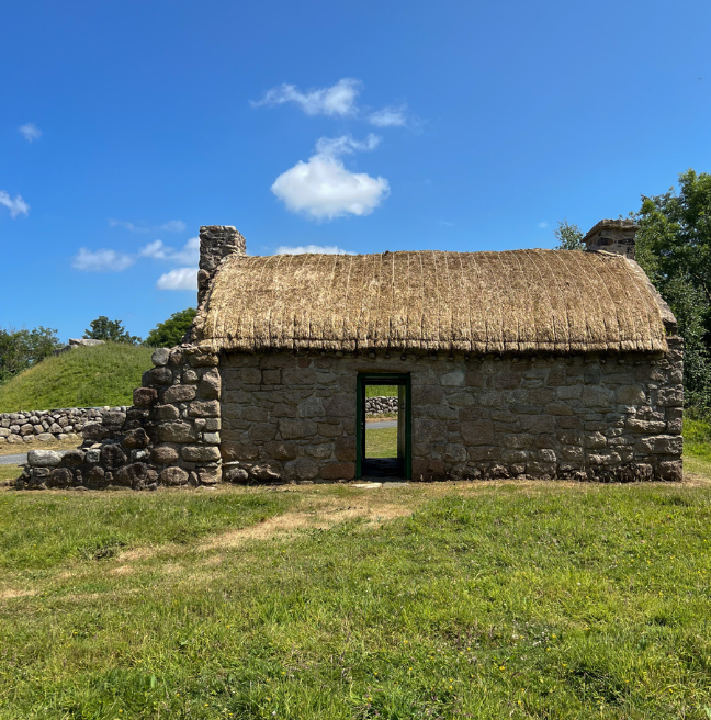 A byre dwelling with its two doors open, so that you can see from one side of the cottage through to the other.