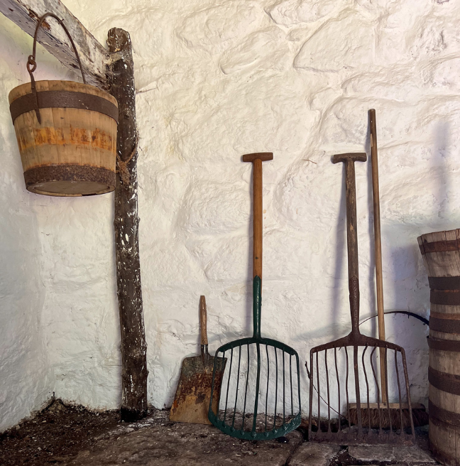 A scene inside a byre dwelling of farming tools.