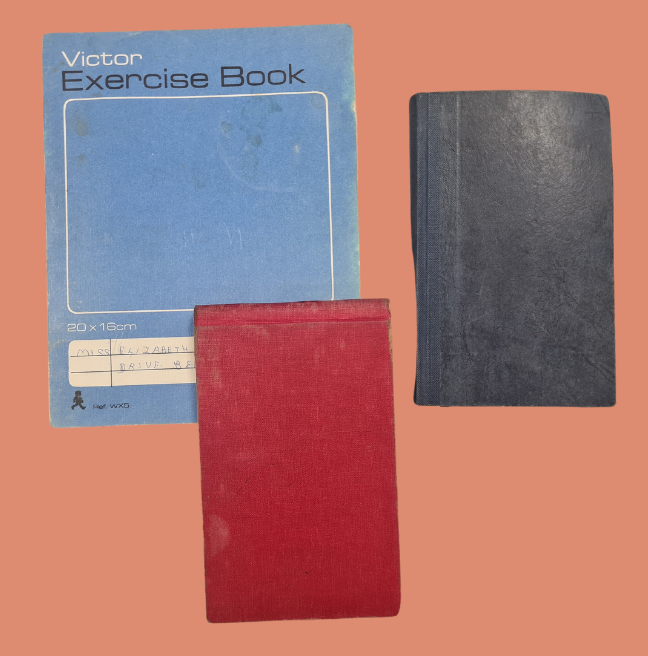Group of Lily Wright's diaries. One large blue diary, one small red diary and a small black diary.