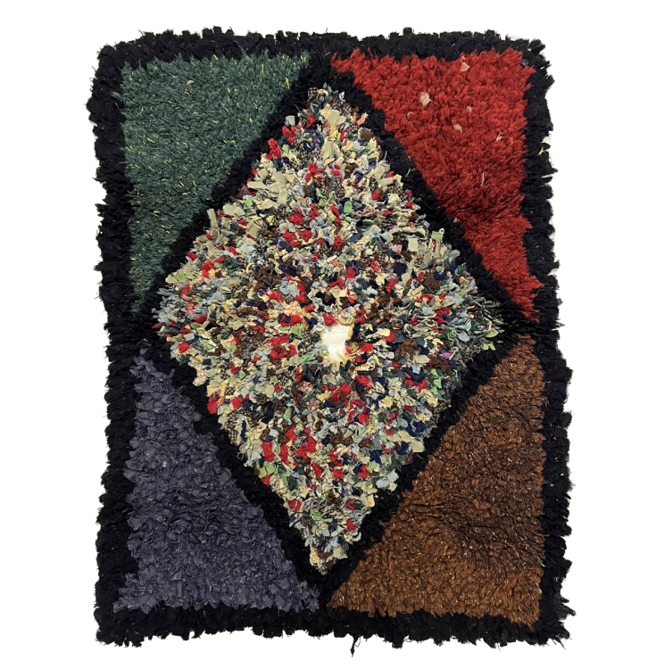 A rectangular rug. The inner shape is multicoloured diamond with a hole inthe middle. It has a black trim.