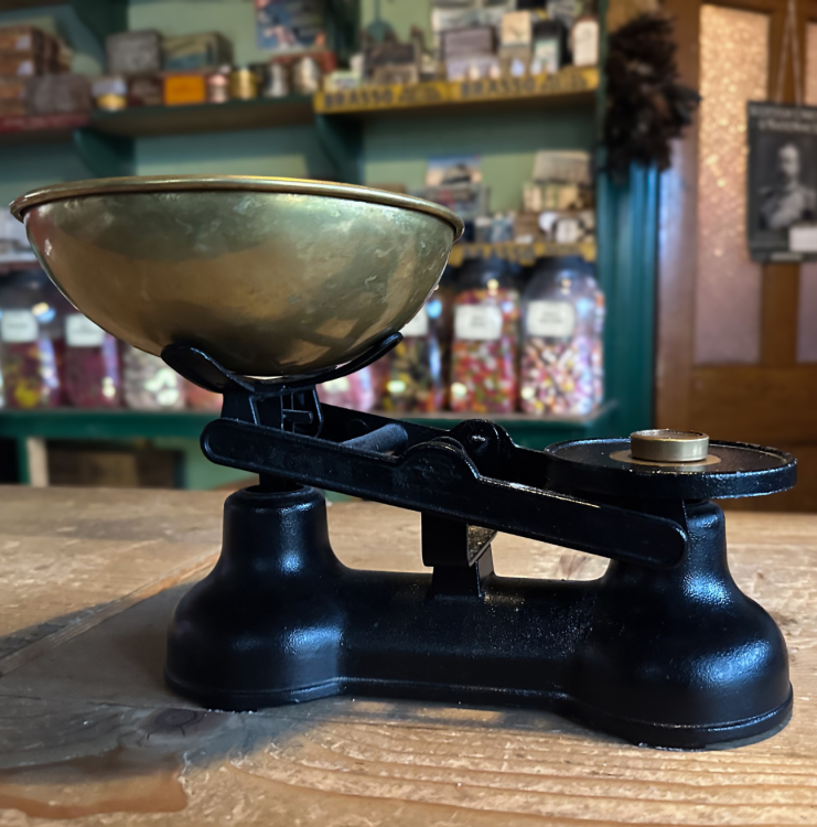 An old fashioned scale sits in a sweet shop.