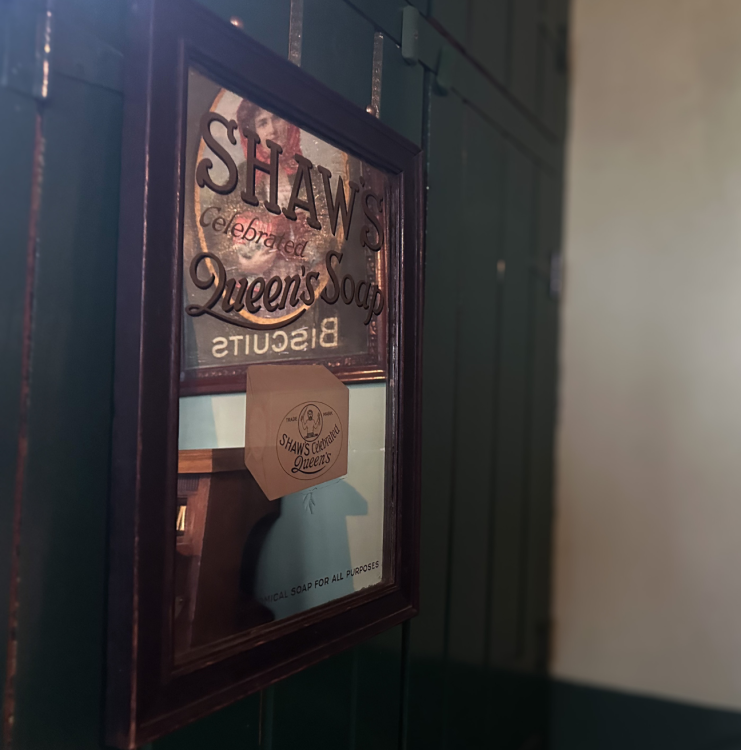 An old mirror with a hand-painted advertisement for soap.