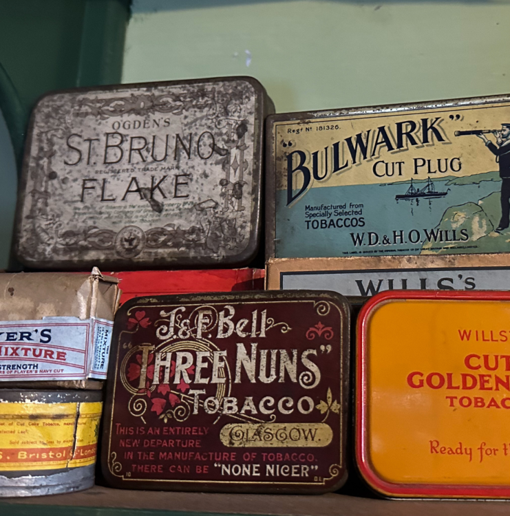 Tins of tobacco sit on a shelf.