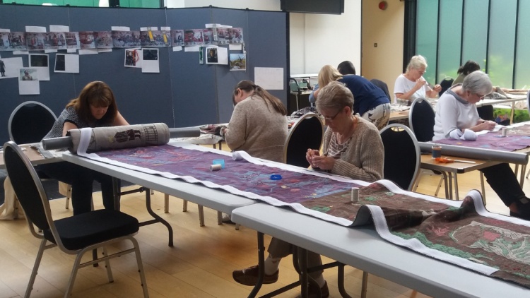 Stitchers at work on the tapestry panels, at the museum during summer 2017