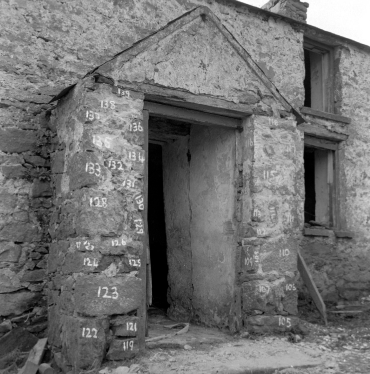 A black and white photograph of a farm building with its bricks numbered.