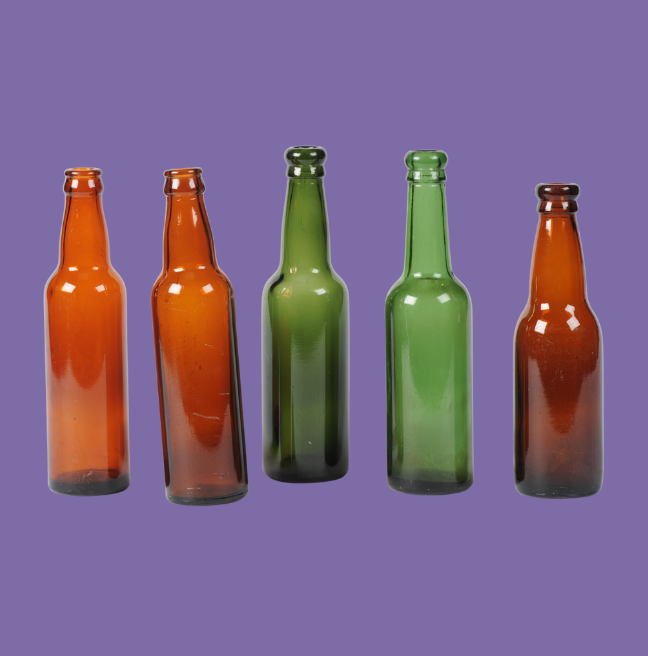 Mix of green and brown glass bottles on a purple background