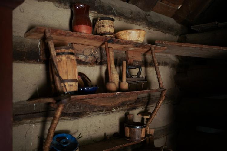 Wooden shelves inside a cabin holding various utensils and storage.