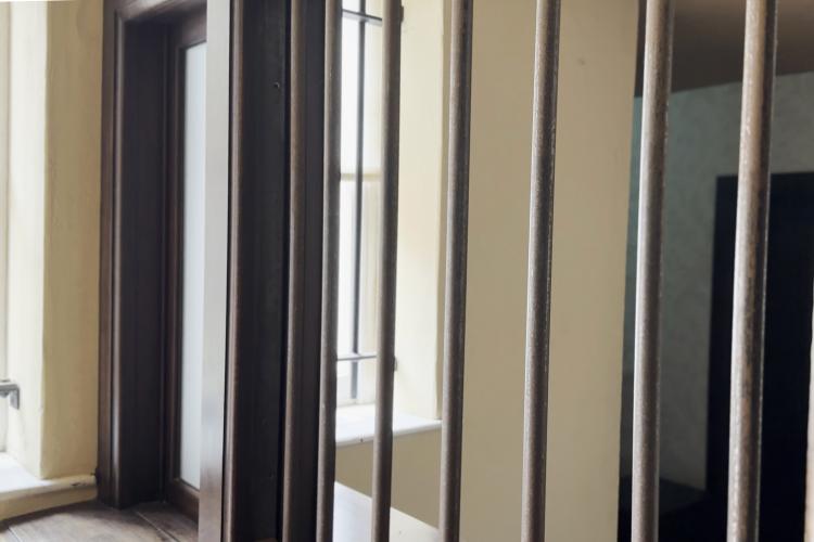 An image of bars separating customers and tellers at a bank.