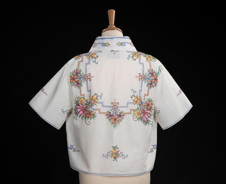 Embroidered table cloth, remade into a cropped blouse with bows on the front and collar. Presented on a bust mannequin with a black background