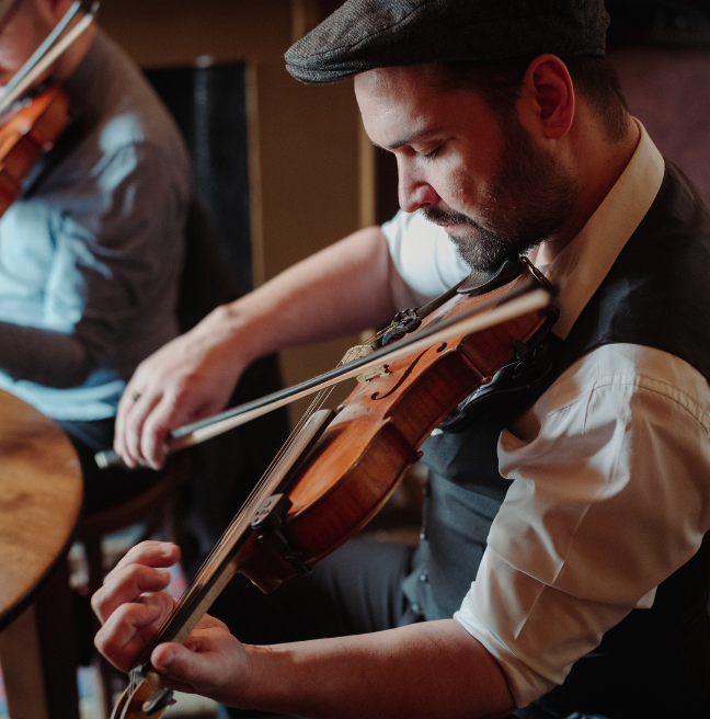 A man playing the fiddle in mccuskers pub