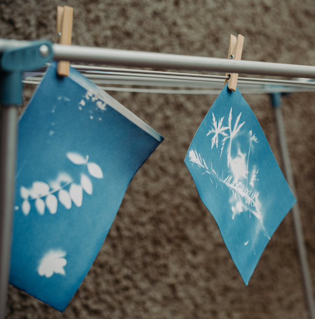 Two blue prints hanging on a line to dry