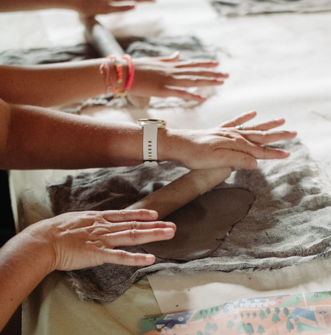 Childrens hands rolling clay 