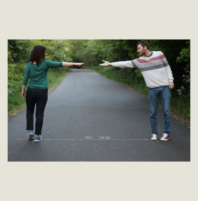 Man and woman standing two metres apart, unable to touch hands. Covid-19 Poster to reflect social distancing