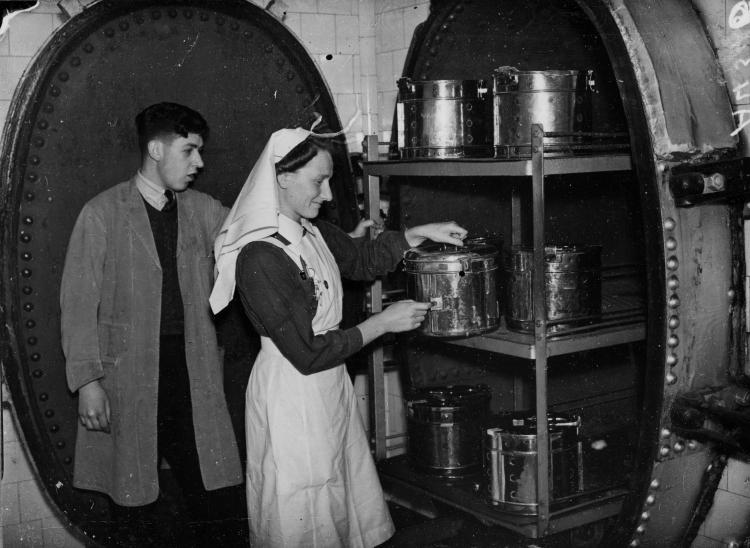 A nurse and a technician are checking sterilisation chambers, a new technology in the 1900s.