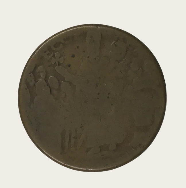 An old, worn coin. An image of St. Patrick holding a three leaf clover is just visible.