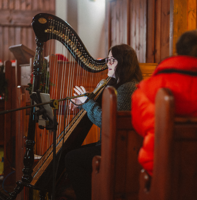 A Brunette lady playing the harp