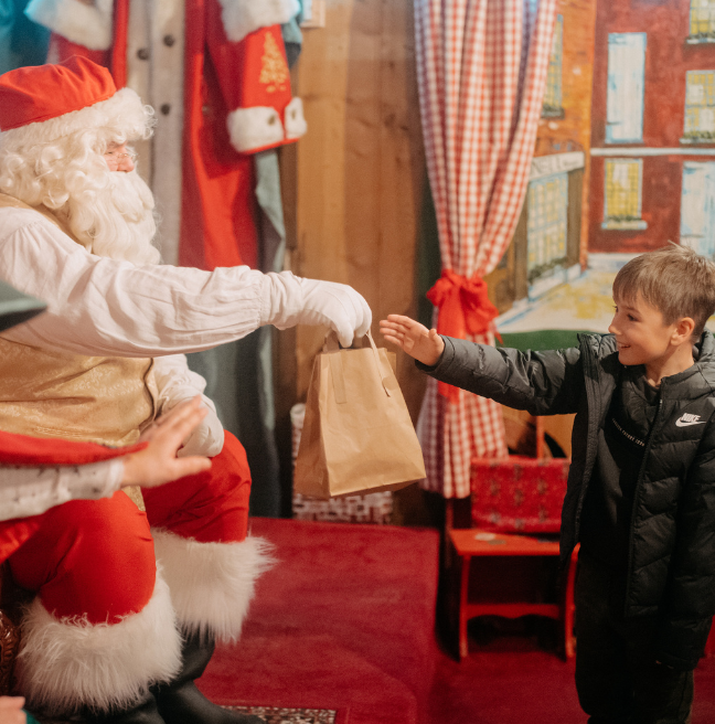 Father Christmas handing a small boy a gift