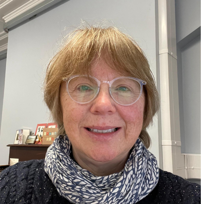 A woman smiles for a self portrait photograph.