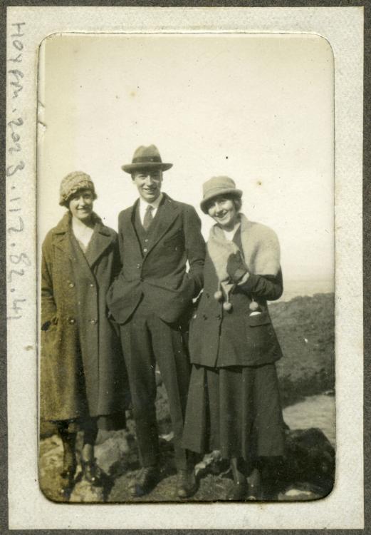 Small photograph of a young in a suit and hat with a two women