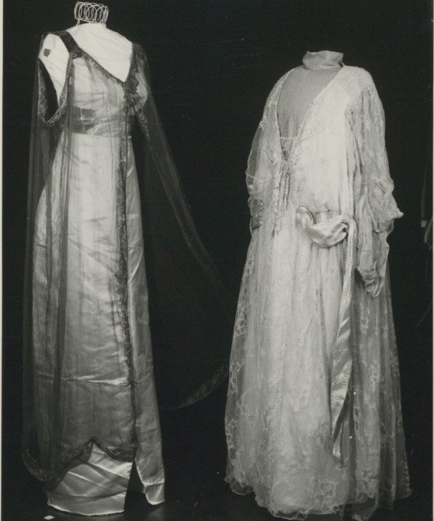 A black and white photograph of a long tea gown with overdress.