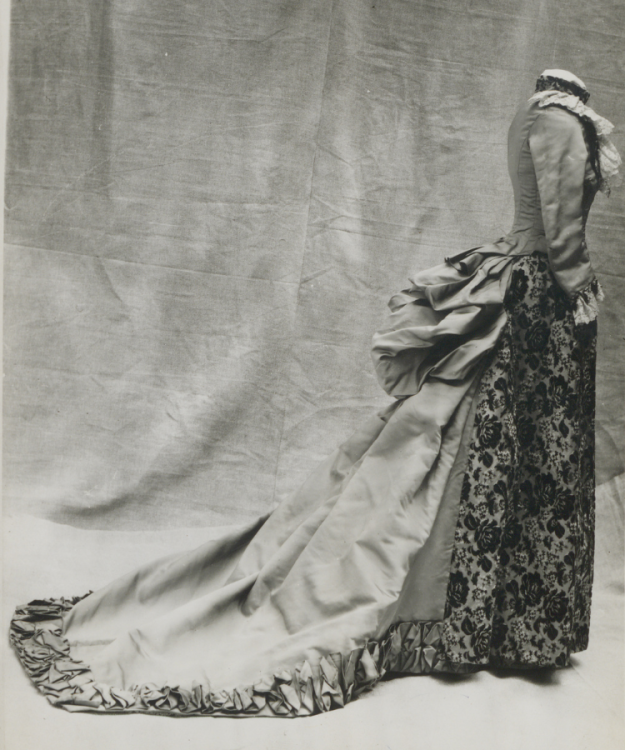 An 1800s wedding dress with a long train and bustle.