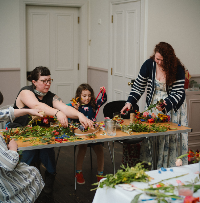 two women and a young girl doing crafts at a table