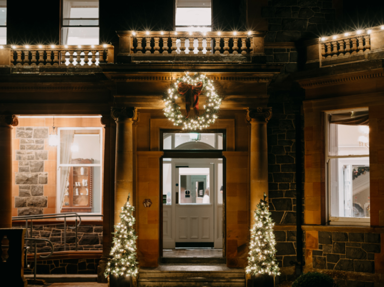 A picture of the entrance to Cultra Manor at night time lit up with Christmas lights