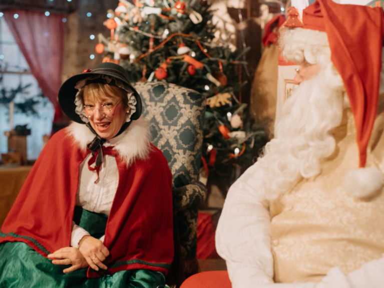 Father Christmas and Mrs Claus talking to a child