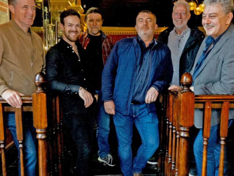 Six men smiling at the camera from the band bow brothers