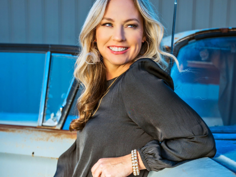 a blonde woman called Kristy Cox wearing a grey top