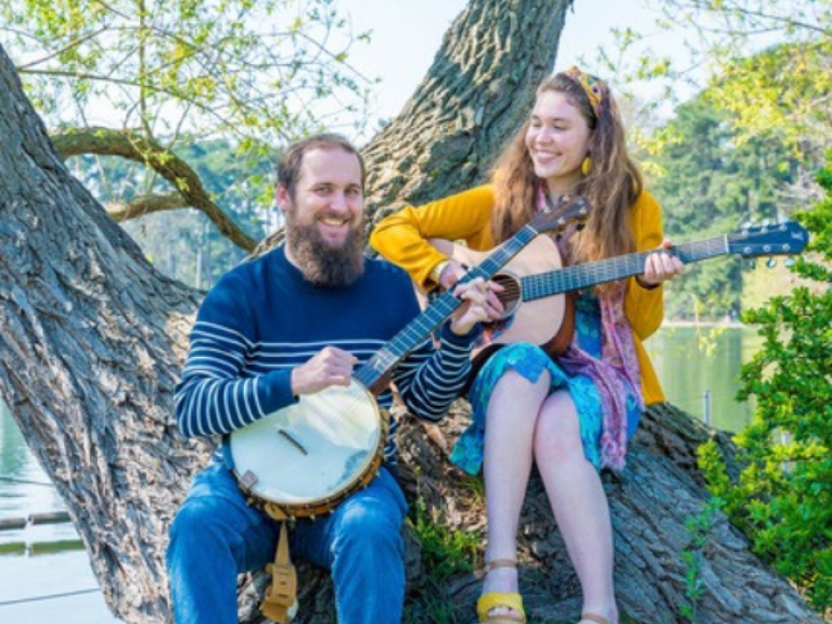 the male and female duo Saelkie Folk carrying two string instruments 