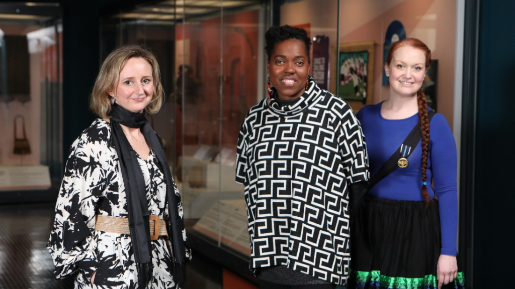 Three people standing inside the Inclusive Global Histories exhibition in the Ulster Museum