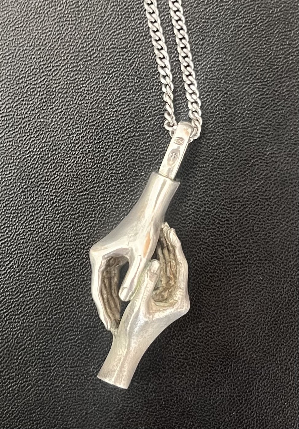 Silver chain with two silver hands, holding
