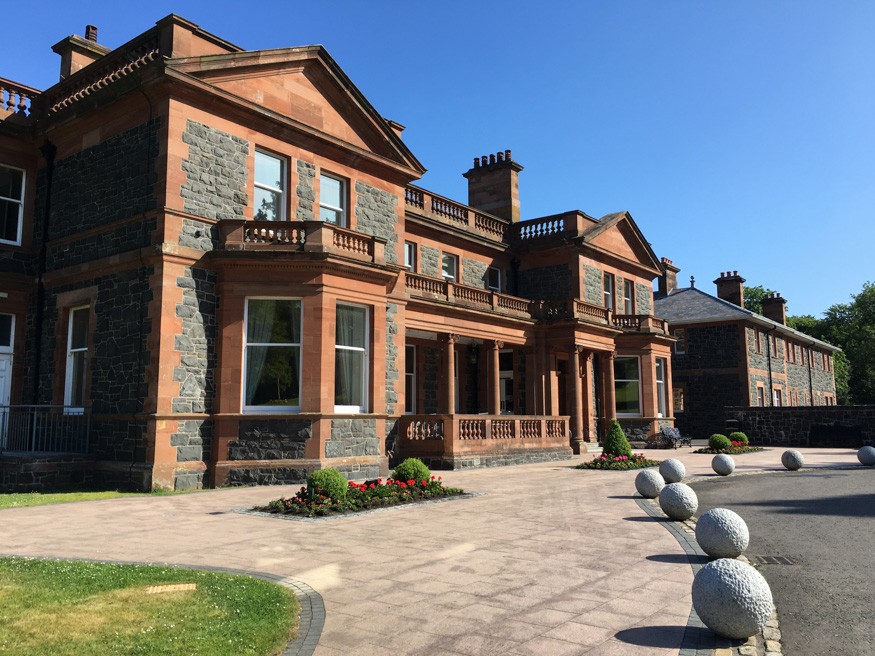 An old manor sits in the sunlight.