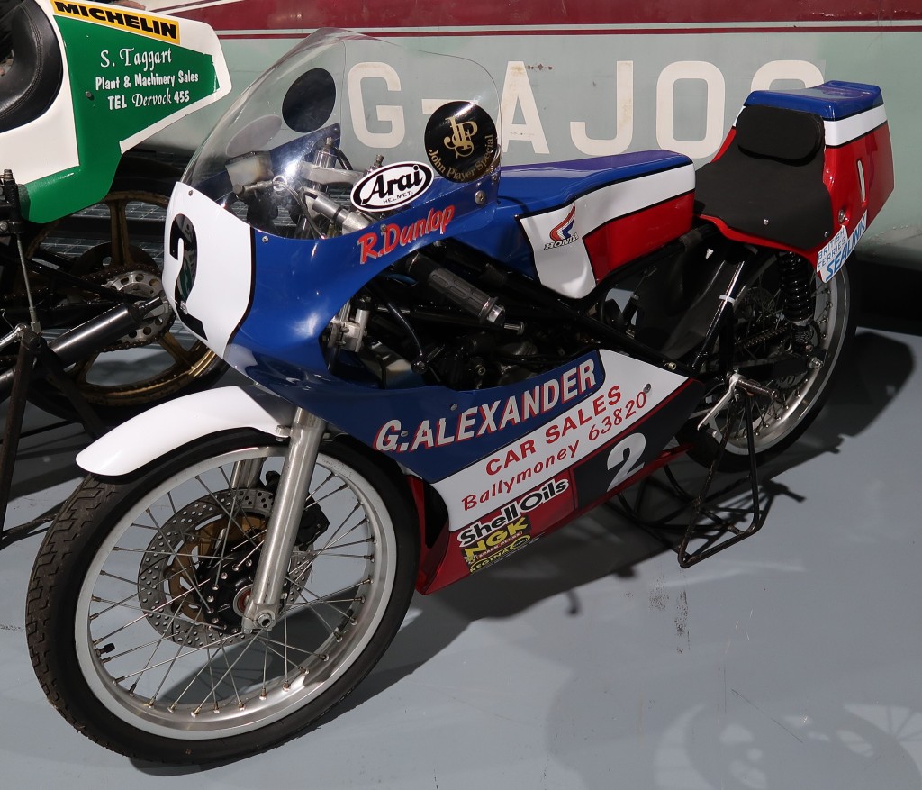 A blue motorcycle sits on a display stand.